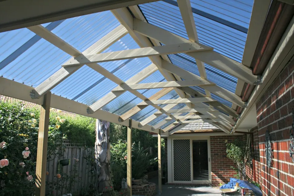 Gable pergola with clear roofing over a paved area